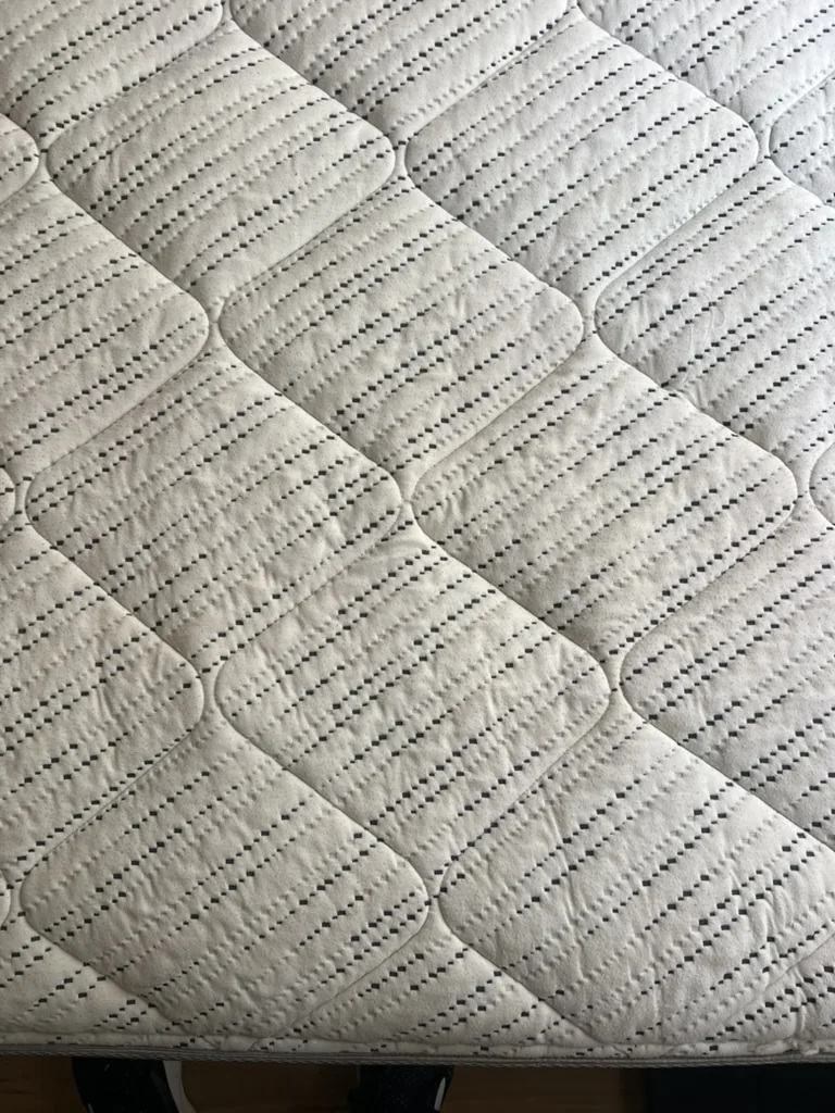 The same quilted mattress after professional cleaning, with much less visible staining
